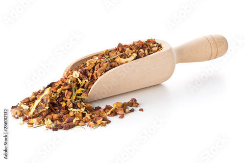 Heap of dried fruit tea infusion with oranges and strawberries mixed with tea leaves and herbs in wooden scoop over white background photo