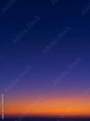 Twilight colorful sky above sea and mountains sihlouettes. © Kostas