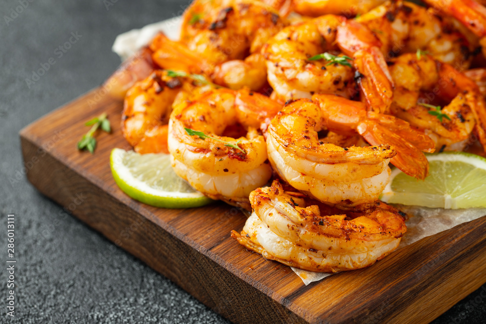Grilled shrimps or prawns served with lime, garlic and white sauce on a dark concrete background. Seafood Grilled shrimps or prawns served with lime, garlic and white sauce on a dark concrete background. Seafood