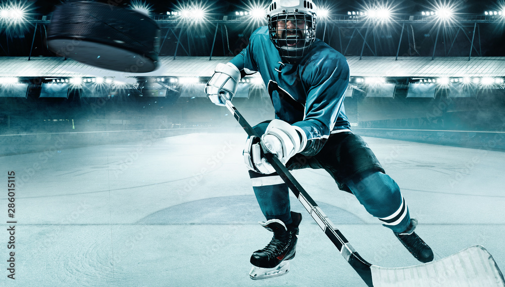 Naklejka premium Ice Hockey player athlete in the helmet and gloves on stadium with stick. Action shot. Sport concept.