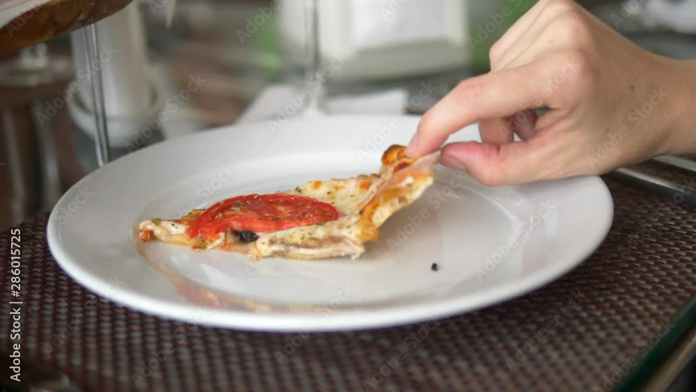 close-up. woman eating pizza while sitting in a restaurant with friends close-up. woman eating pizza while sitting in a restaurant with friends