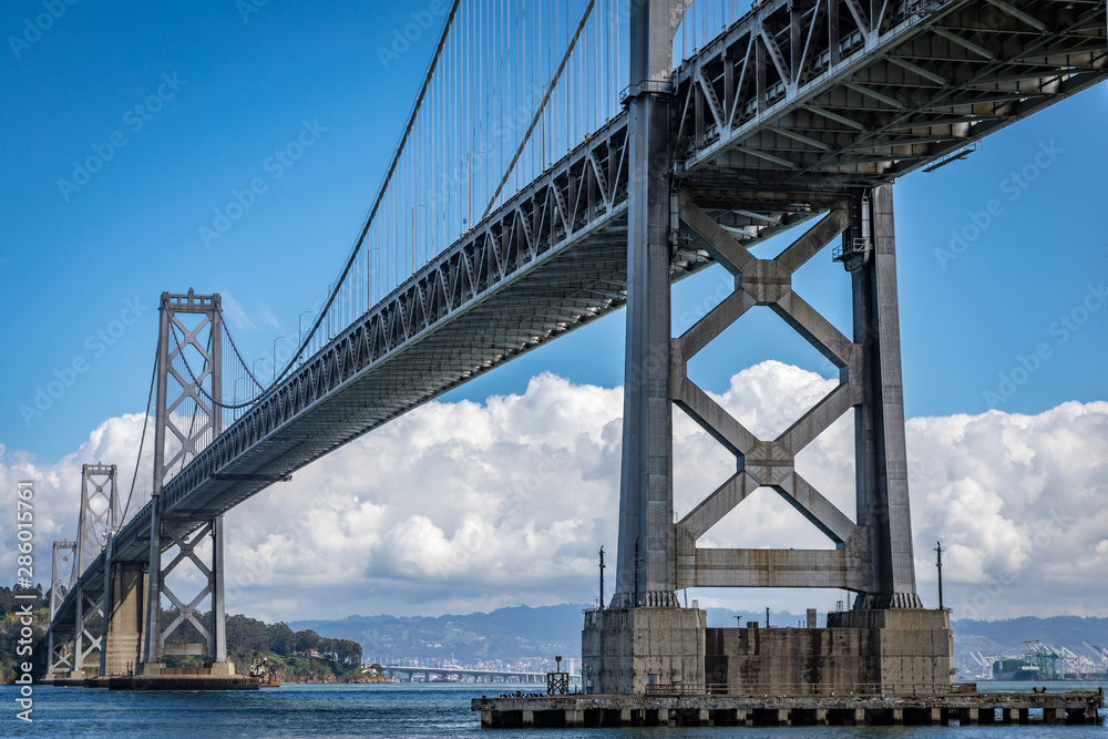 San Francisco bay bridge on a clear day with white clouds in the background