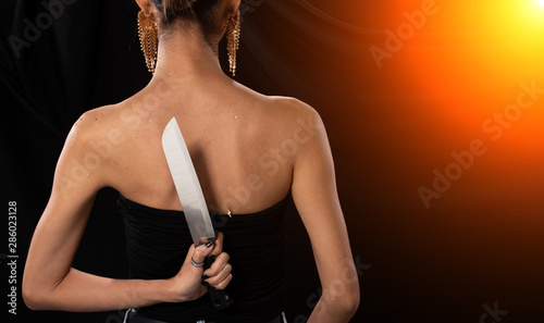 Fotografija Back side view of Asian Woman long hair hold Kitchen sharp Knife in hand, studio