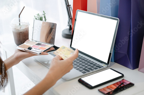 Mockup image of beautiful woman holding credit card enjoying in shopping website online with smartphone and laptop, mockup concept