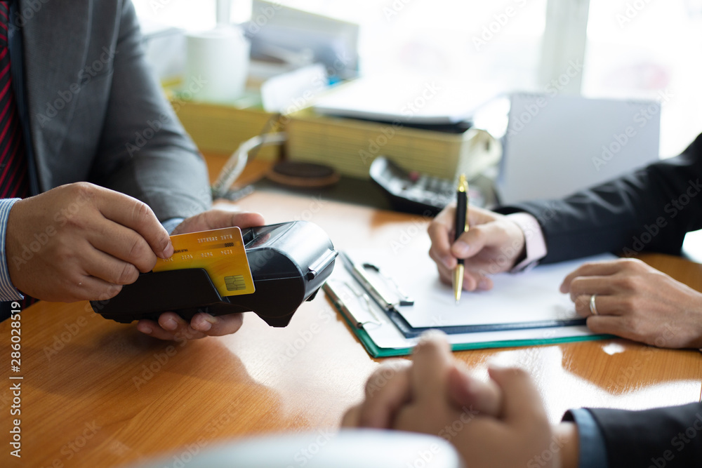 Φωτογραφία Close up of hands businessman use a credit card swipe to pay for the share transfer fees in the investment of the company