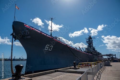 Battleship USS Missouri with sun, blue sky, and clouds at Pearl Harbor, Hawaii Fotobehang
