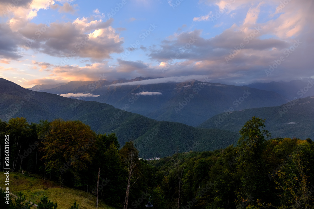  Mountainous woodland with cloudy sky at sunset