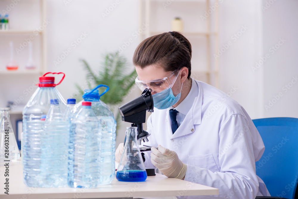 Young male chemist experimenting in lab Young male chemist experimenting in lab