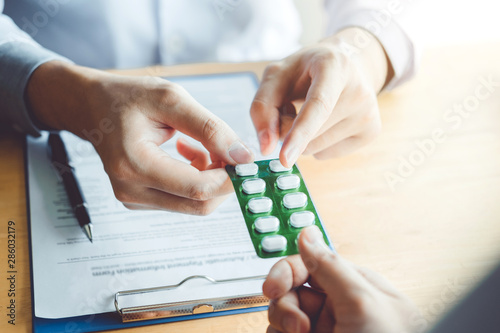 Doctor or physician recommend pills medical prescription to male Patient  hospital and medicine concept