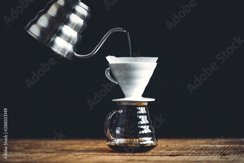Foto black coffee drip On the wood Dark tone