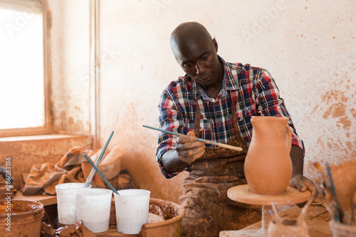 Potter painting ceramic pot