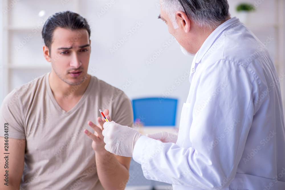 Obraz premium Male patient visitng doctor for shot inoculation