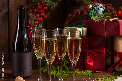 Christmas holiday table with glasses and a bottle of wine of champagne. Eve of new year, preparation and laying of a wooden holiday table © chernikovatv