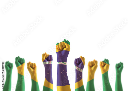 Photography Brazil flag on people hands with clenched fists raising up for labor day nationa