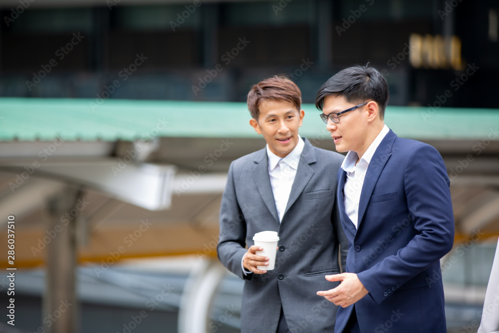 Two businessmen talking at outdoor against building Two businessmen talking at outdoor against building