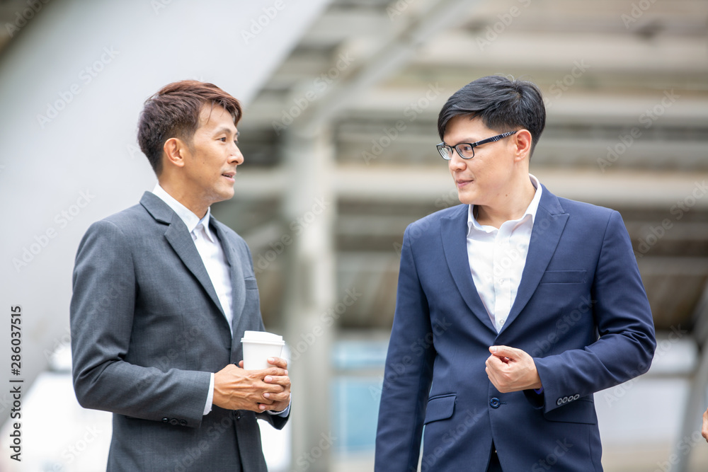 Two businessmen talking at outdoor against building Two businessmen talking at outdoor against building