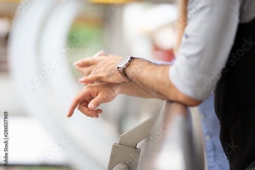 Closeup of man hands with watch by rail 