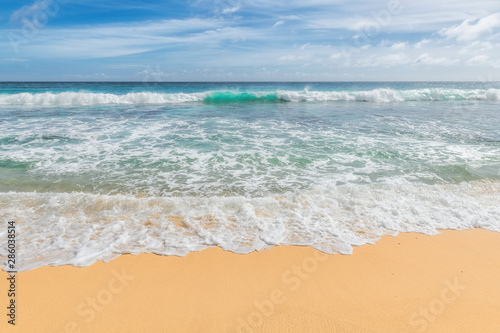 Beautiful ocean sandy beach with soft blue wave and golden sand.