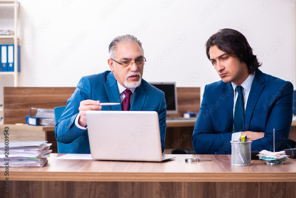 Young and old employees working together in the office Young and old employees working together in the office