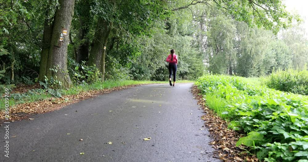 Young woman during her training in the forest. Health jogging. Girl professes health lifestyle. Shallow DOF. Young woman during her training in the forest. Health jogging. Girl professes health lifestyle. Shallow DOF.