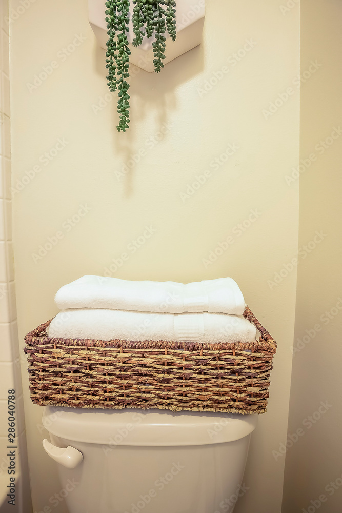 Folded Towels Inside A Rattan Bathroom Tray Placed On Top Of The Toilet Tank  Stock Photo | Adobe Stock