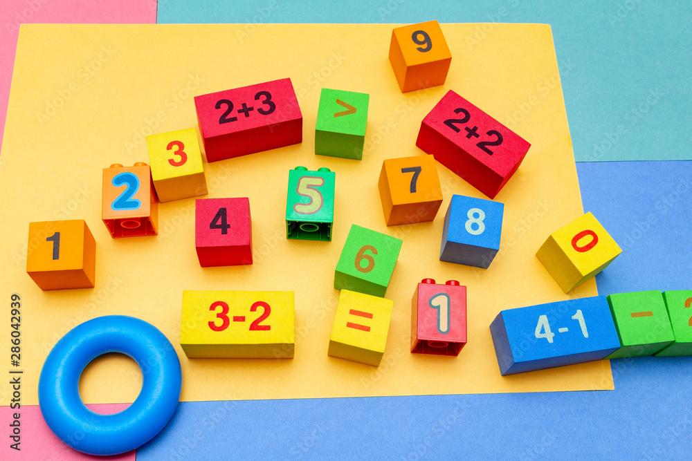 child kid colorful education toys cubes with numbers math pattern background on the bright background. Flat lay. Childhood infancy children babies concept. child kid colorful education toys cubes with numbers math pattern background on the bright background. Flat lay. Childhood infancy children babies concept.