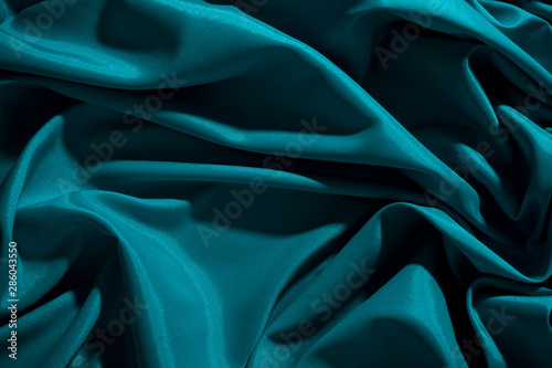 Background image of crumpled fabric. Blue silk