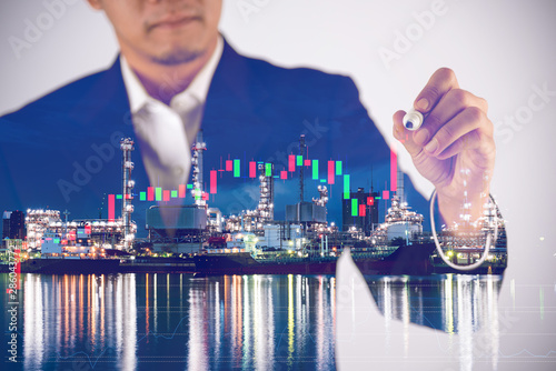 double expore of businessman white graph on screen and oil refinery plant photo