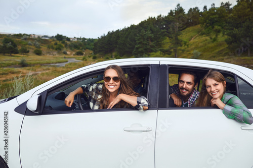 A group of happy friends are driving in a car. © Studio Romantic