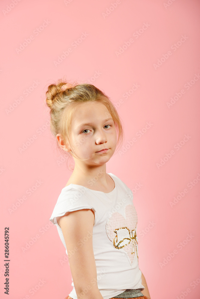 Fashionable girl posing in the studio on a pink background. Fashionable girl posing in the studio on a pink background.