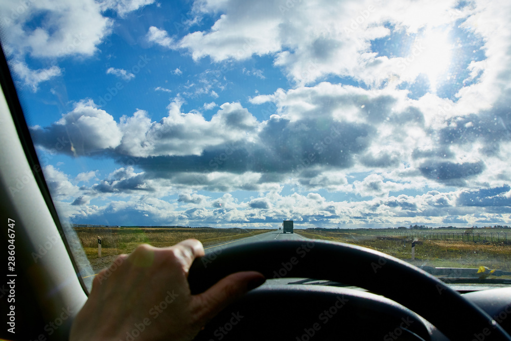 Track from the car window and white clouds on blue sky. Natural landscape Track from the car window and white clouds on blue sky. Natural landscape