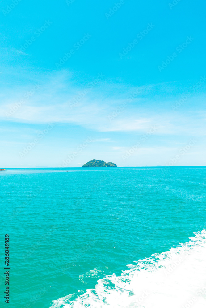 Fototapeta premium Looking at the Island, blue water and sky.