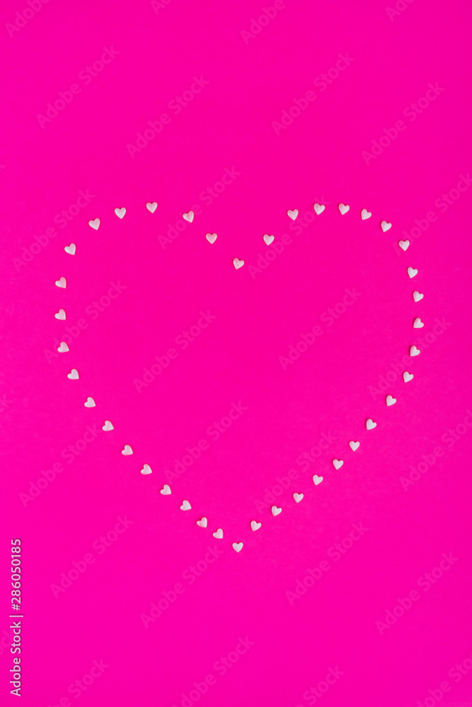 Pink confetti heart on bright pink background. Flat lay, top view, copy space.