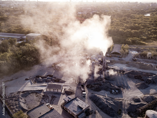 Air pollution by smoke coming out factory chimneys. Aerial