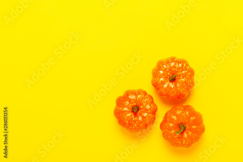 Decorative pumpkins on a yellow background. Halloween concept, harvest, autumn. Flat lay, top view