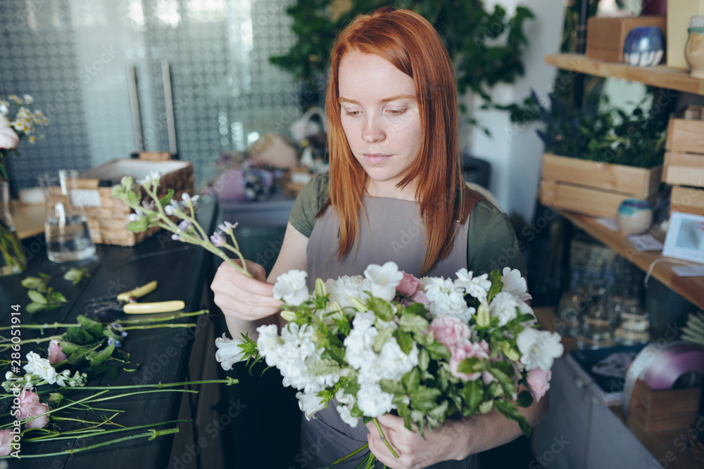 Creative florist arranging wedding bouquet