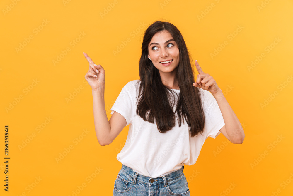 Image of pretty brunette woman with long hair smiling and pointing fingers at copyspace Image of pretty brunette woman with long hair smiling and pointing fingers at copyspace