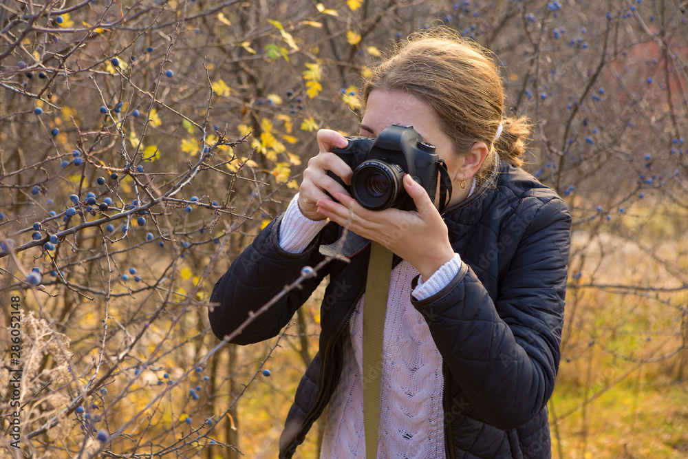 A girl with a camera in her hands in a funny pose makes a frame. Paparazi with a camera in his hands on an outbreak in the mountains. A girl with a camera in her hands in a funny pose makes a frame. Paparazi with a camera in his hands on an outbreak in the mountains.