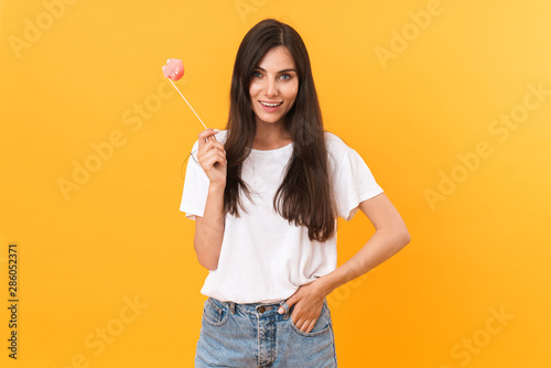 Image of gorgeous brunette woman wearing basic clothes smiling and holding paper lips