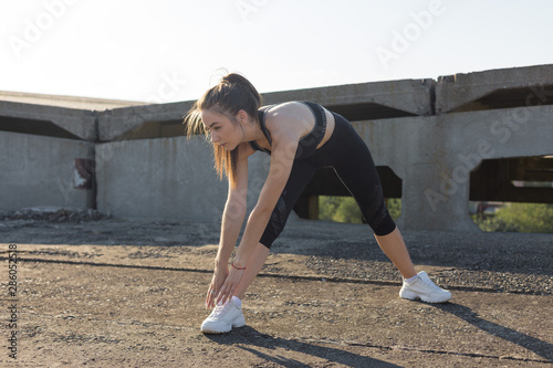 A young slim athletic girl in sportswear with snakeskin prints performs a set of exercises. Fitness and healthy lifestyle. 