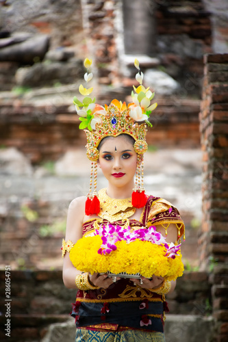 Portrait of an Balinese dancer is holding oblation after prayer in Traditional Attire at Bali Gate