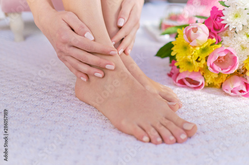 ideally made manicure and pedicure. Women's legs and hands on the background of flowers © Berg