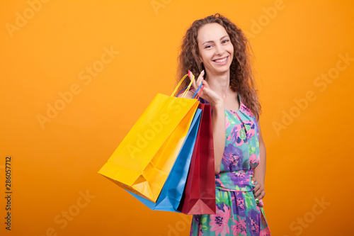 Woman with a big smile in studio holding shopping bags