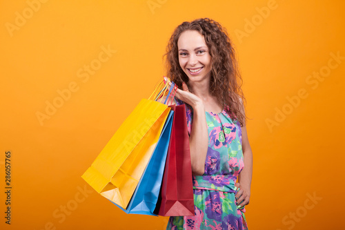 Attractive woman in pretty dress holding shopping bags