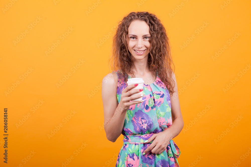 Delighted female in summer dress holding a cup of coffee Delighted female in summer dress holding a cup of coffee