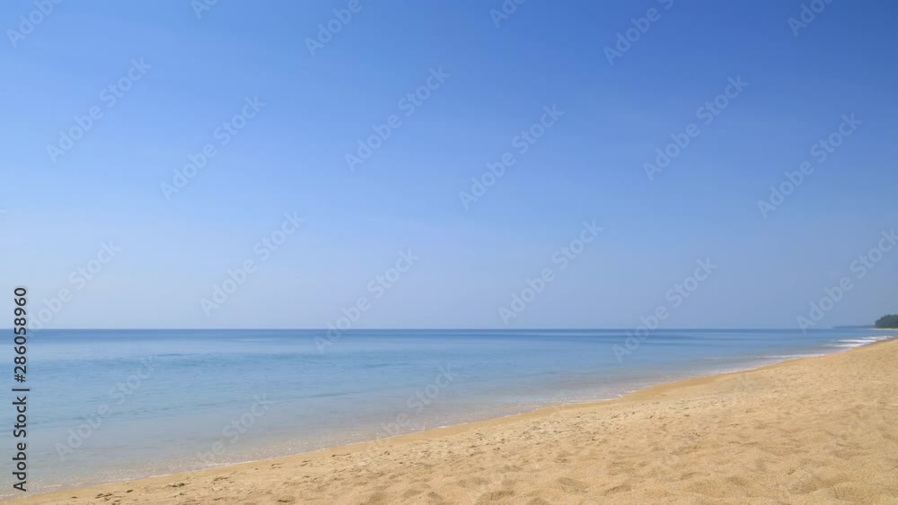 Beautiful tropical beach with yellow sand, blue sky and clear water with waves Beautiful tropical beach with yellow sand, blue sky and clear water with waves
