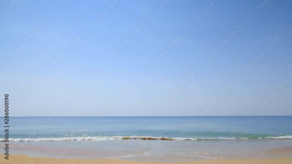 Tropical beach in sunny day with blue foamy waves and water horizon Tropical beach in sunny day with blue foamy waves and water horizon