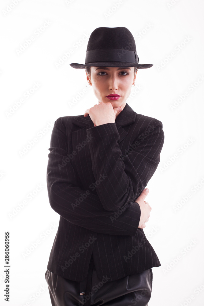 Beautiful young model posing in studio with a retro hat wearing a stylish black jacket Beautiful young model posing in studio with a retro hat wearing a stylish black jacket