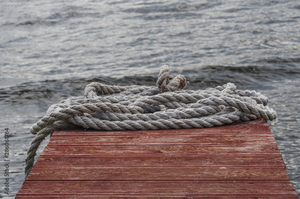 Shabby rope lies on a red wooden pier