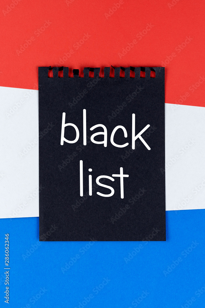 Blacklist Holland. Mourning, ban, sanctions, politics. black sheet of notebook lies on holland flag. Mock up, copy space, pattern, cardboard texture. Blacklist Holland. Mourning, ban, sanctions, politics. black sheet of notebook lies on holland flag. Mock up, copy space, pattern, cardboard texture.